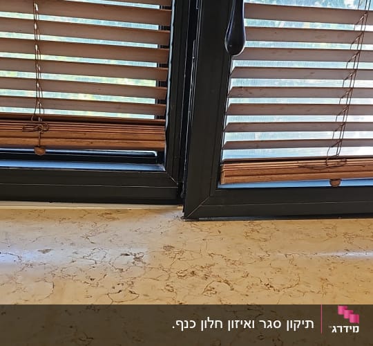 חלון אלומיניום כהה על ציר מעל אדן חלון משיש